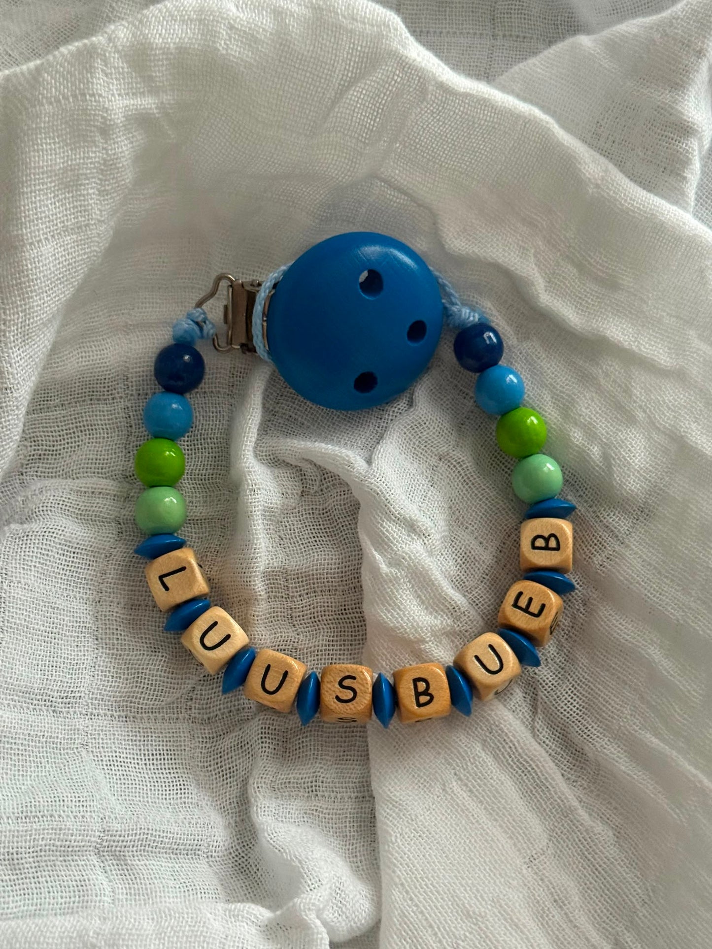 Nuggikette "Luusbuebl" (Farbe: blau, grün Material: Holz)