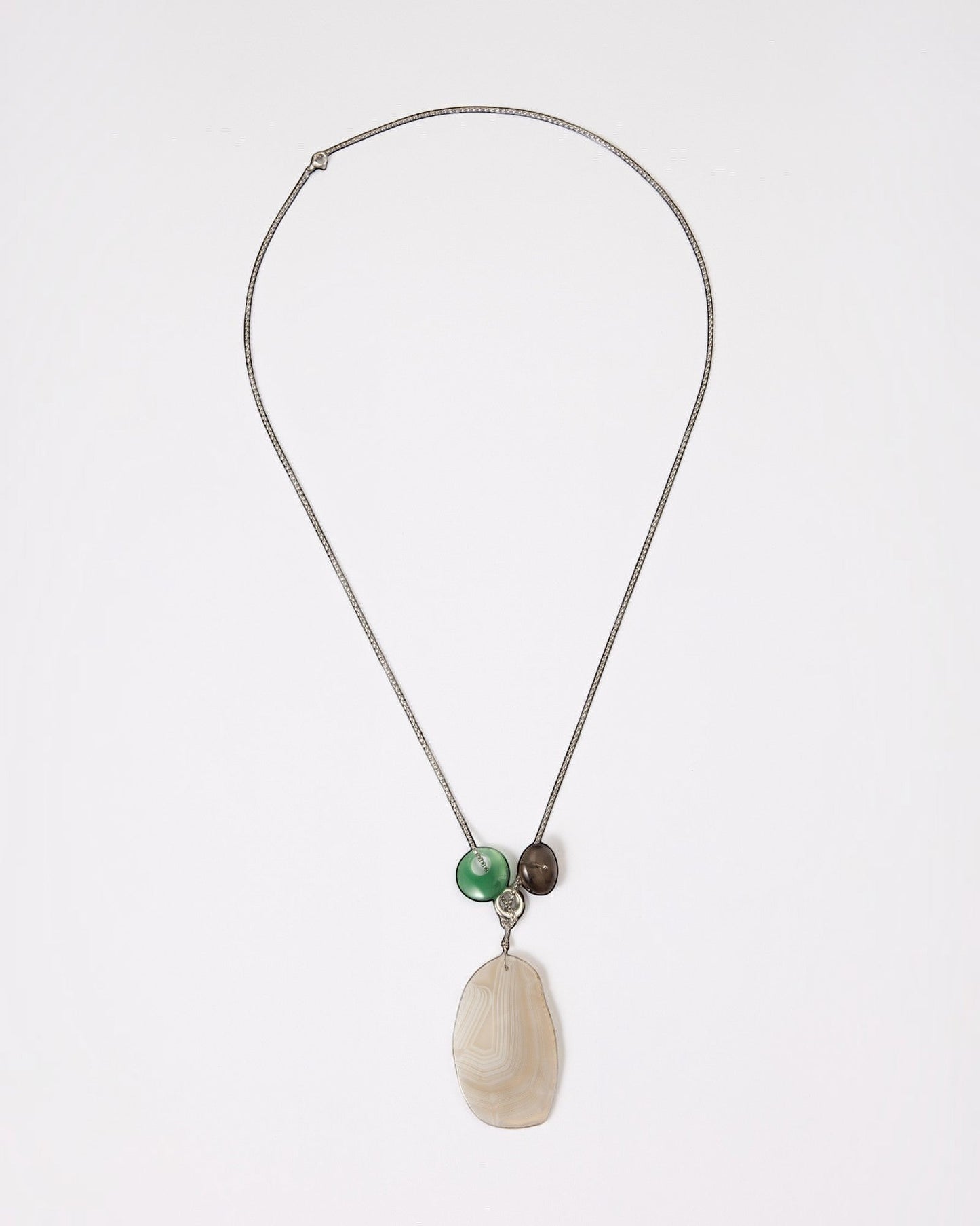Elsita Jewelry Glacier Night necklace featuring a white agate slice, green agate ring, and smoky quartz on a silver chain.