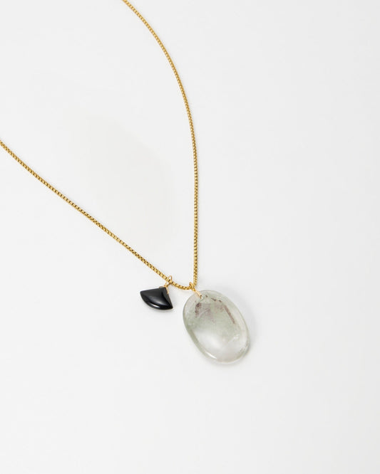 Elsita Jewelry Mist III necklace featuring a gold chain with a clear quartz pendant and a small black accent stone