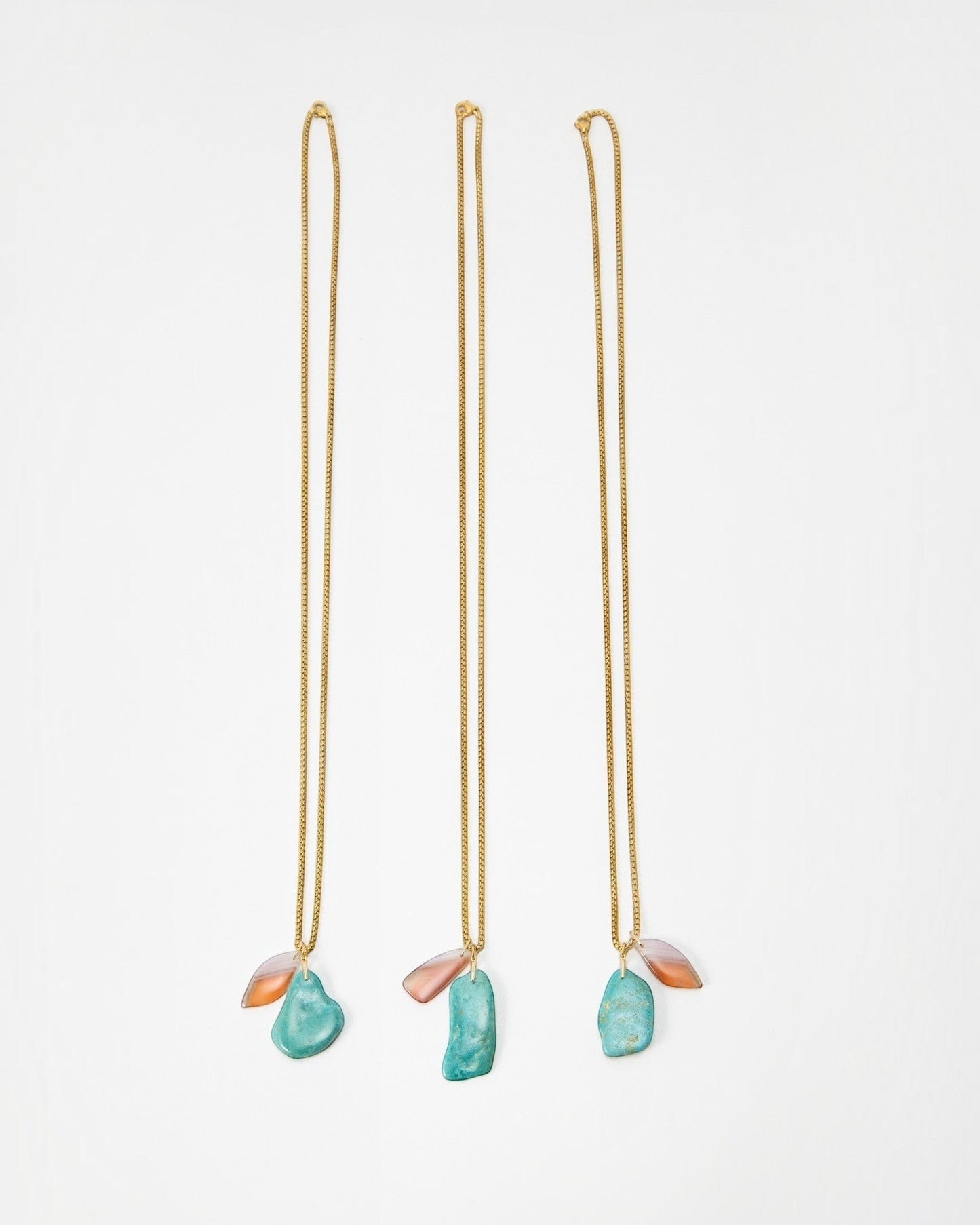 Elsita Jewelry Rusty II gold chain necklaces featuring organic turquoise and translucent peach stone pendants