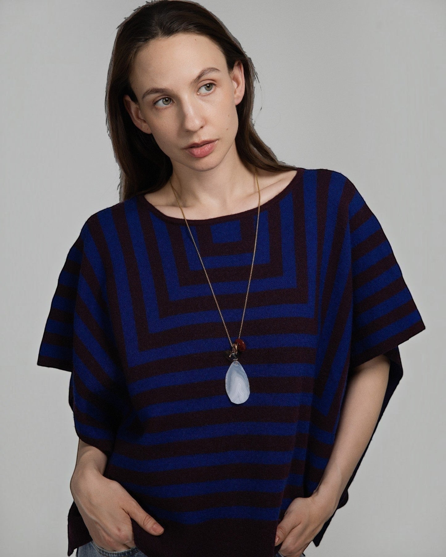 Model wearing Elsita Jewelry Glacier Day necklace with white agate, smoky quartz, and red agate on a gold-tone chain.