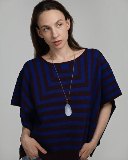 Model wearing Elsita Jewelry Glacier Day necklace with white agate, smoky quartz, and red agate on a gold-tone chain.