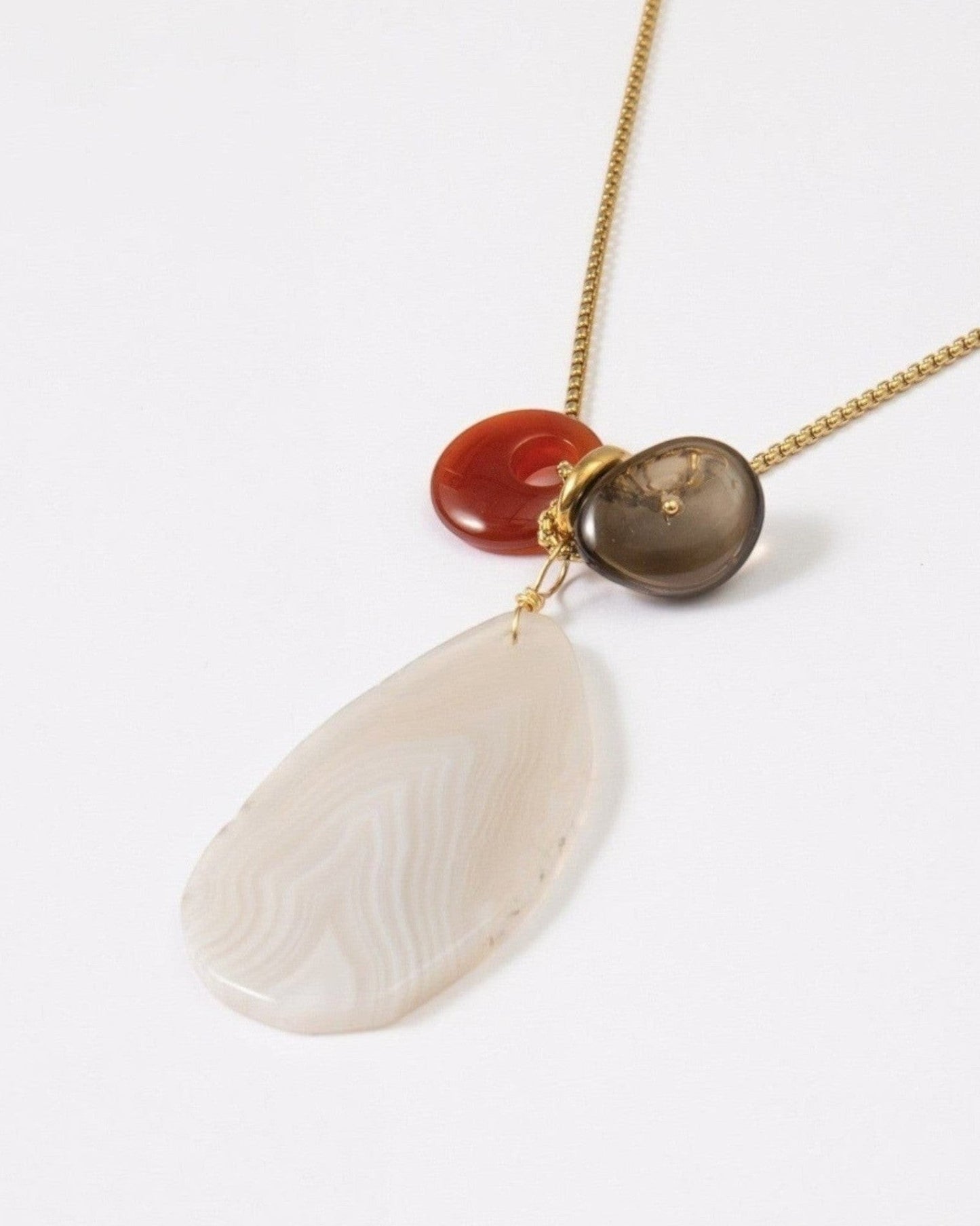 Elsita Jewelry Glacier Day necklace featuring a white agate slice, red agate, and smoky quartz on a gold-tone chain.