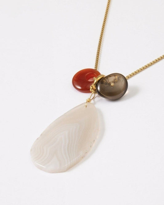 Elsita Jewelry Glacier Day necklace featuring a white agate slice, red agate, and smoky quartz on a gold-tone chain.