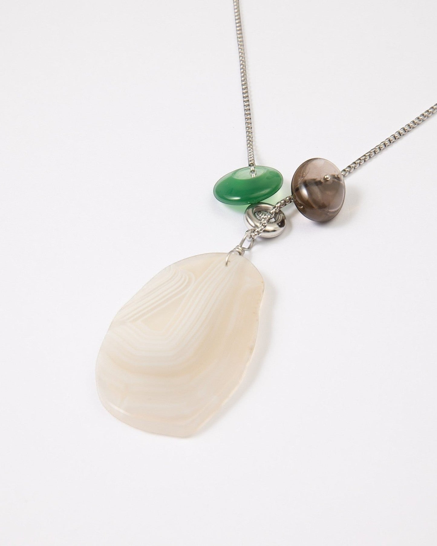 Elsita Jewelry Glacier Night necklace featuring a white agate pendant, green agate, and smoky quartz on a silver chain.