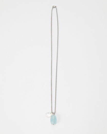 Elsita Jewelry Azul necklace featuring a light blue faceted gemstone and a small white pearl charm on a silver chain