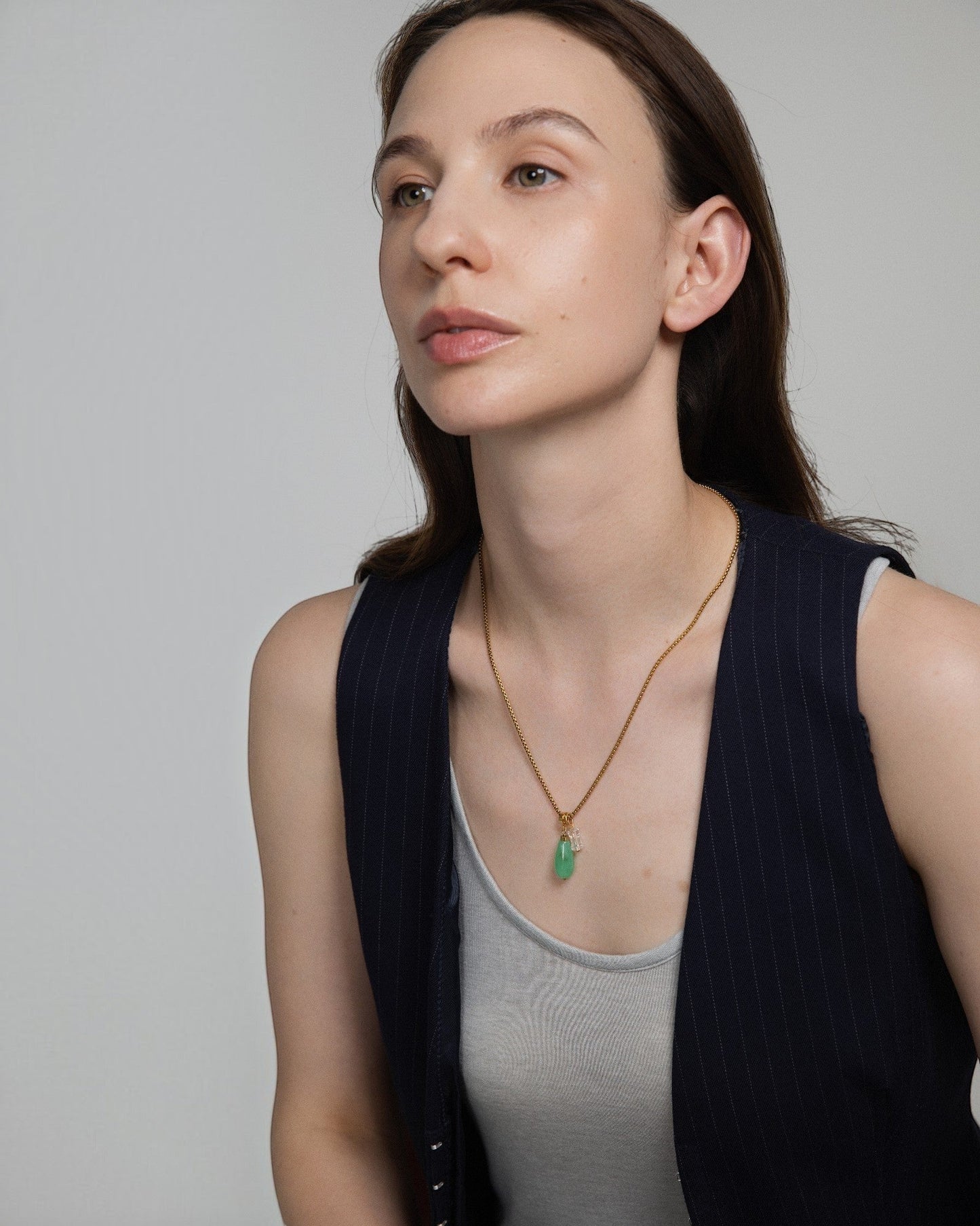 Model wearing Elsita Jewelry Bamboo necklace with green chrysoprase and clear quartz pendant on a gold chain.