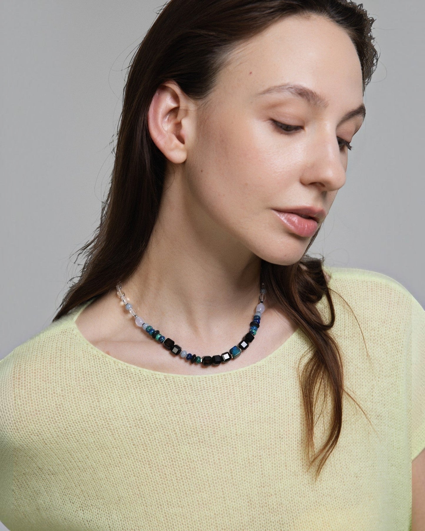 Elsita Jewelry Blausee Deep necklace featuring faceted black agate, chrysocolla, and chalcedony beads on a model.