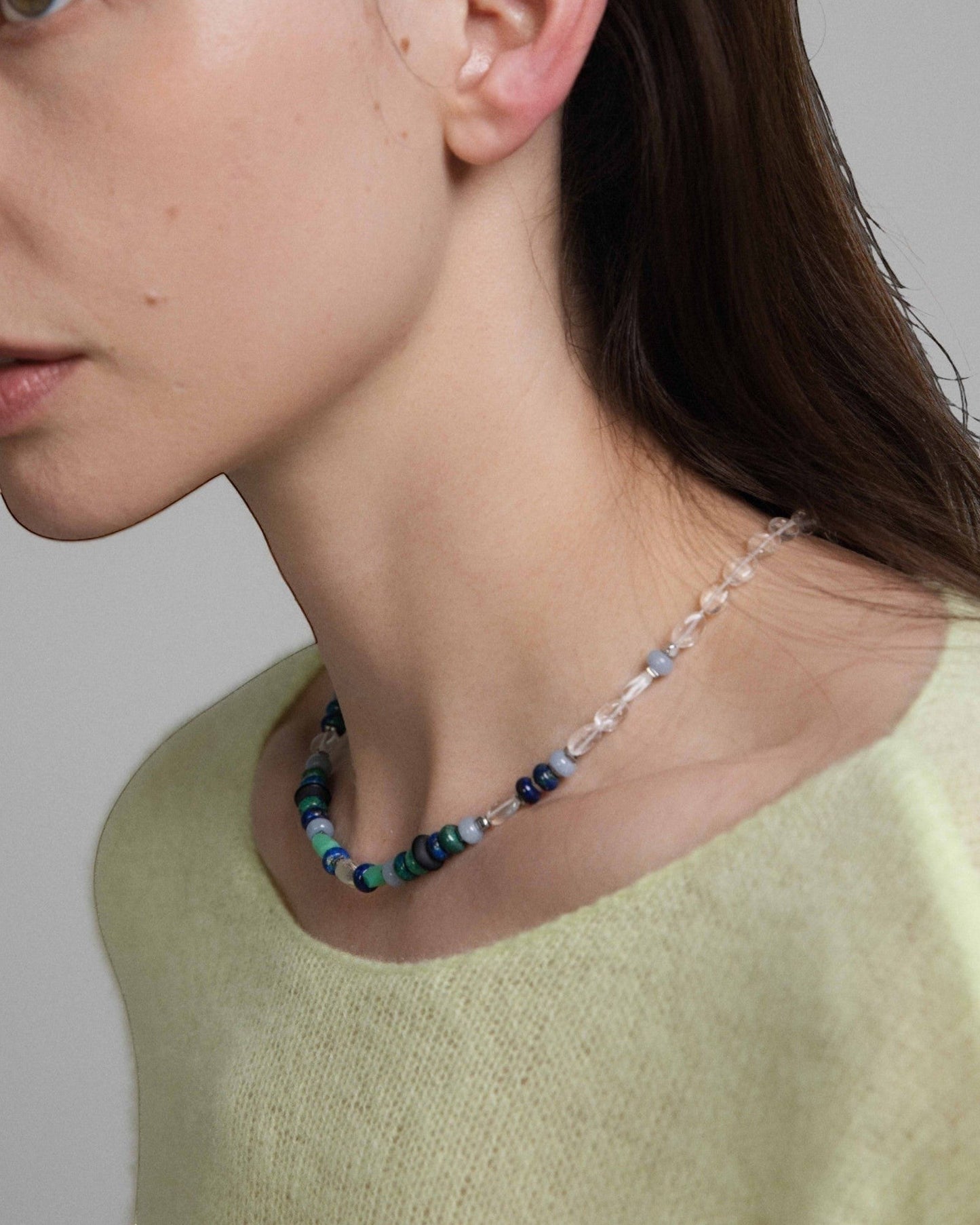 Model wearing Elsita Jewelry Blausee Light necklace featuring chrysocolla, chrysoprase, and clear quartz beads.
