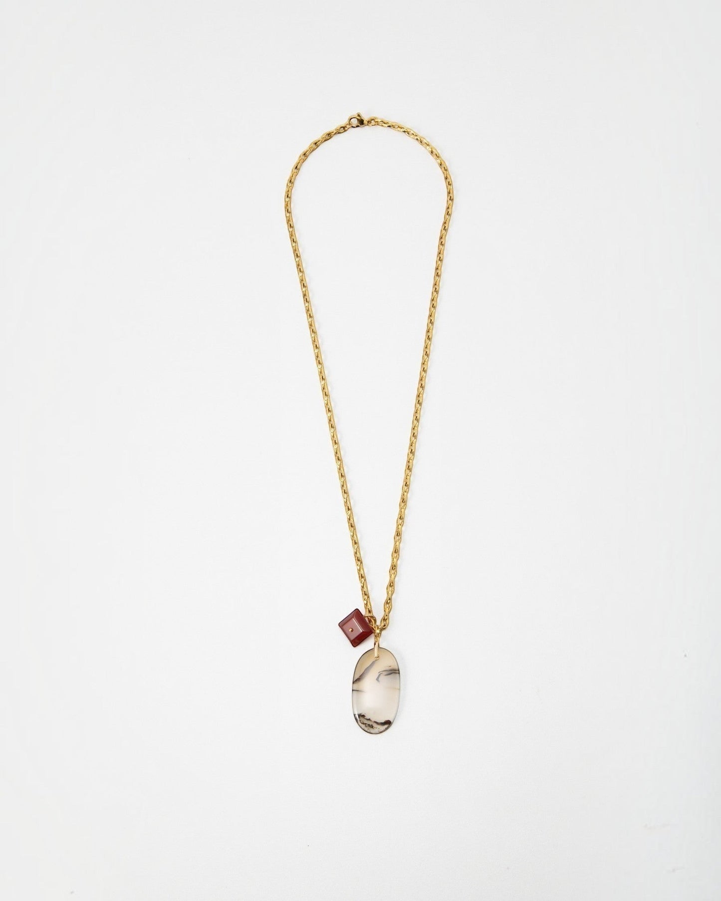 Elsita Jewelry Calligraphy necklace featuring a gold chain with a large oval agate pendant and a small red cube charm