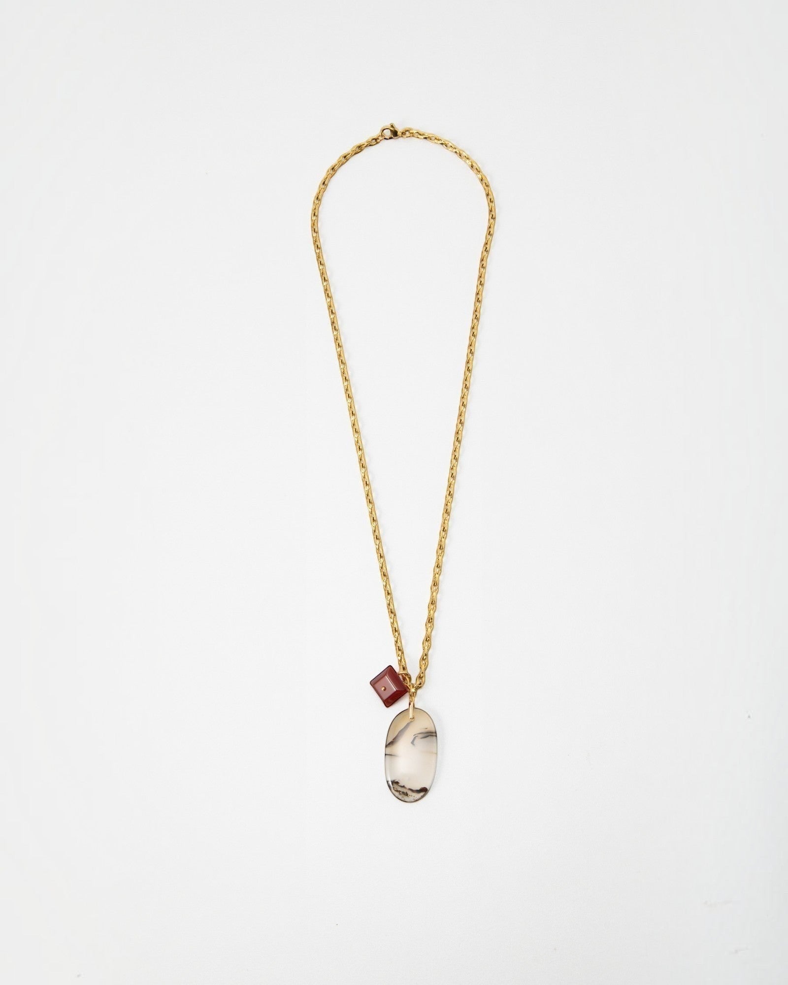 Elsita Jewelry Calligraphy necklace featuring a gold chain with a large oval agate pendant and a small red cube charm