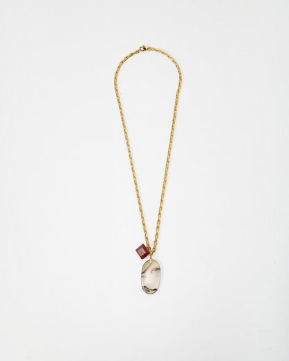 Elsita Jewelry Calligraphy necklace featuring a gold chain with a large oval agate pendant and a small red cube charm