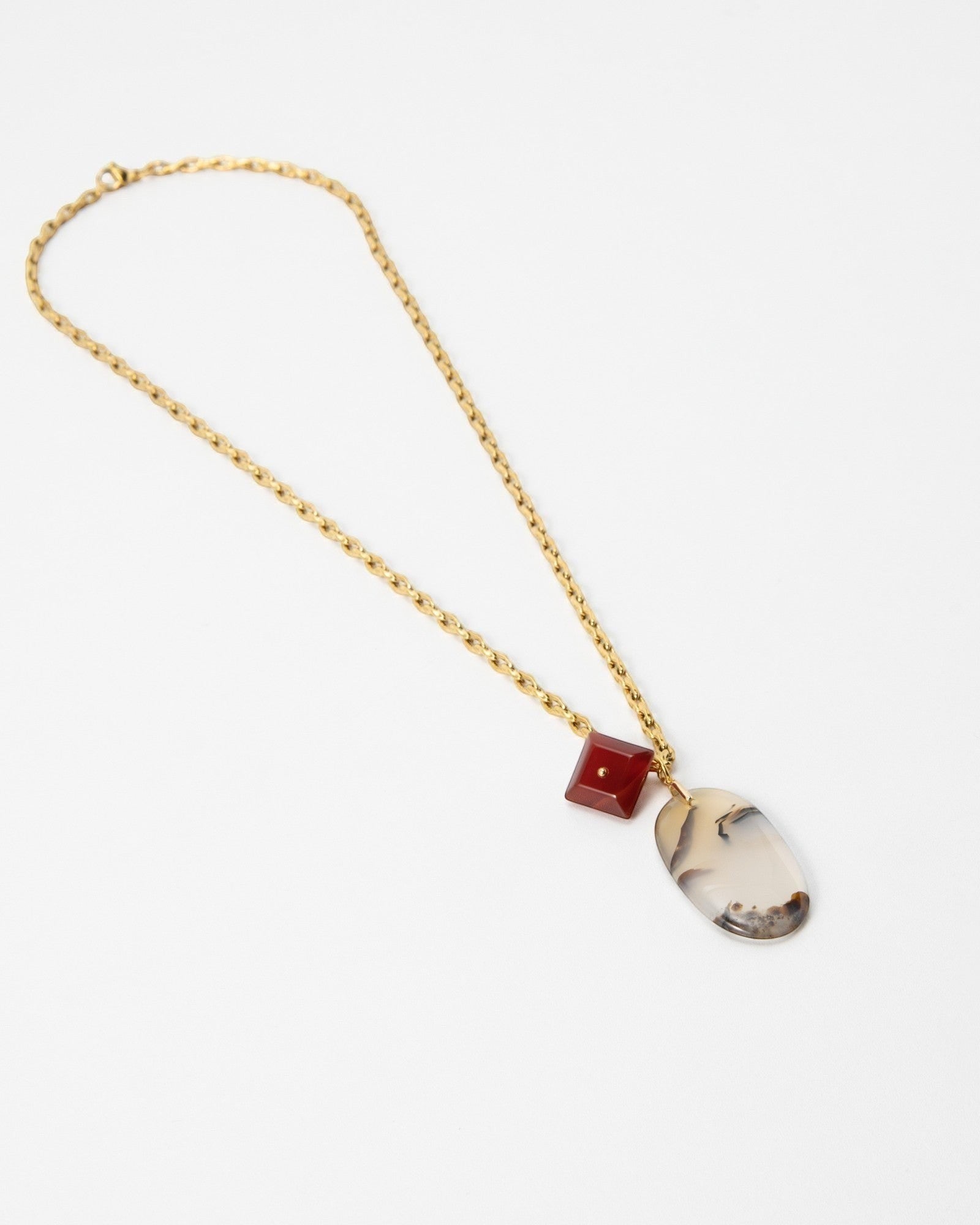 Elsita Jewelry Calligraphy necklace featuring a gold chain, a red square bead, and an oval dendritic agate pendant.