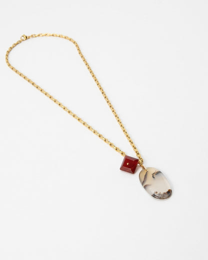 Elsita Jewelry Calligraphy necklace featuring a gold chain, a red square bead, and an oval dendritic agate pendant.