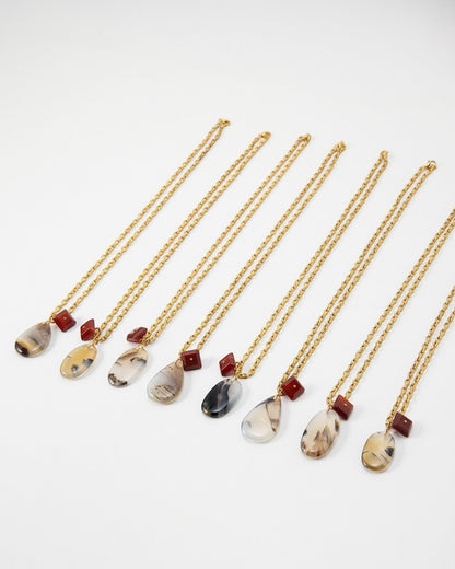 Elsita Jewelry Calligraphy necklaces featuring teardrop-shaped agate pendants and small red square beads on gold chains