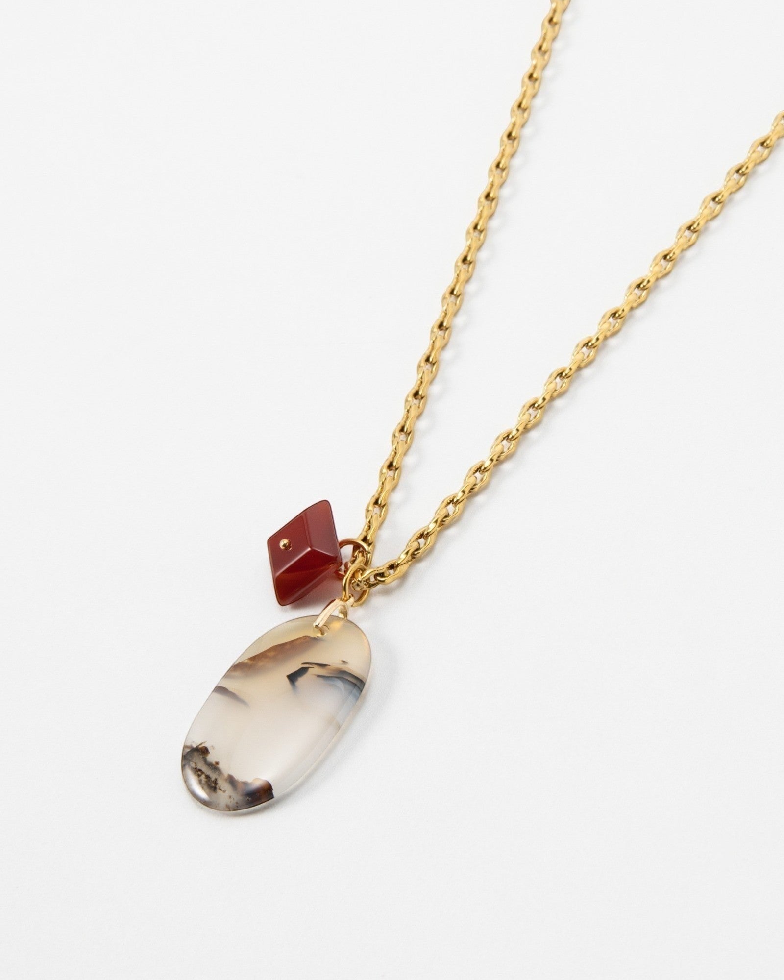 Elsita Jewelry Calligraphy necklace featuring an oval agate pendant and a small red charm on a gold chain