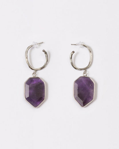 Elsita Jewelry Calm amethyst earrings featuring geometric deep violet stones on silver hoops against a white background.