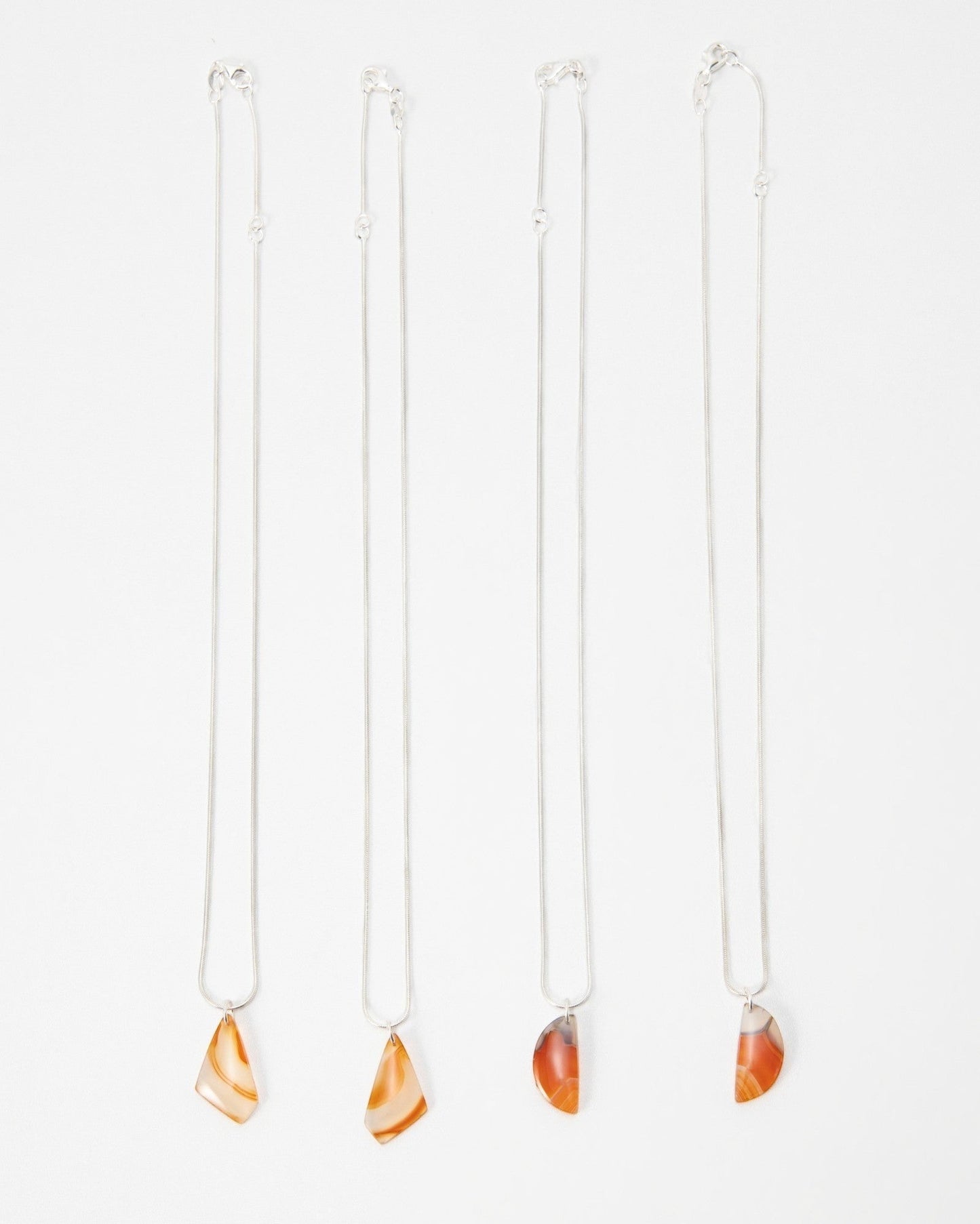 Elsita Jewelry Citrus II necklaces featuring polished orange and red agate pendants on delicate silver chains