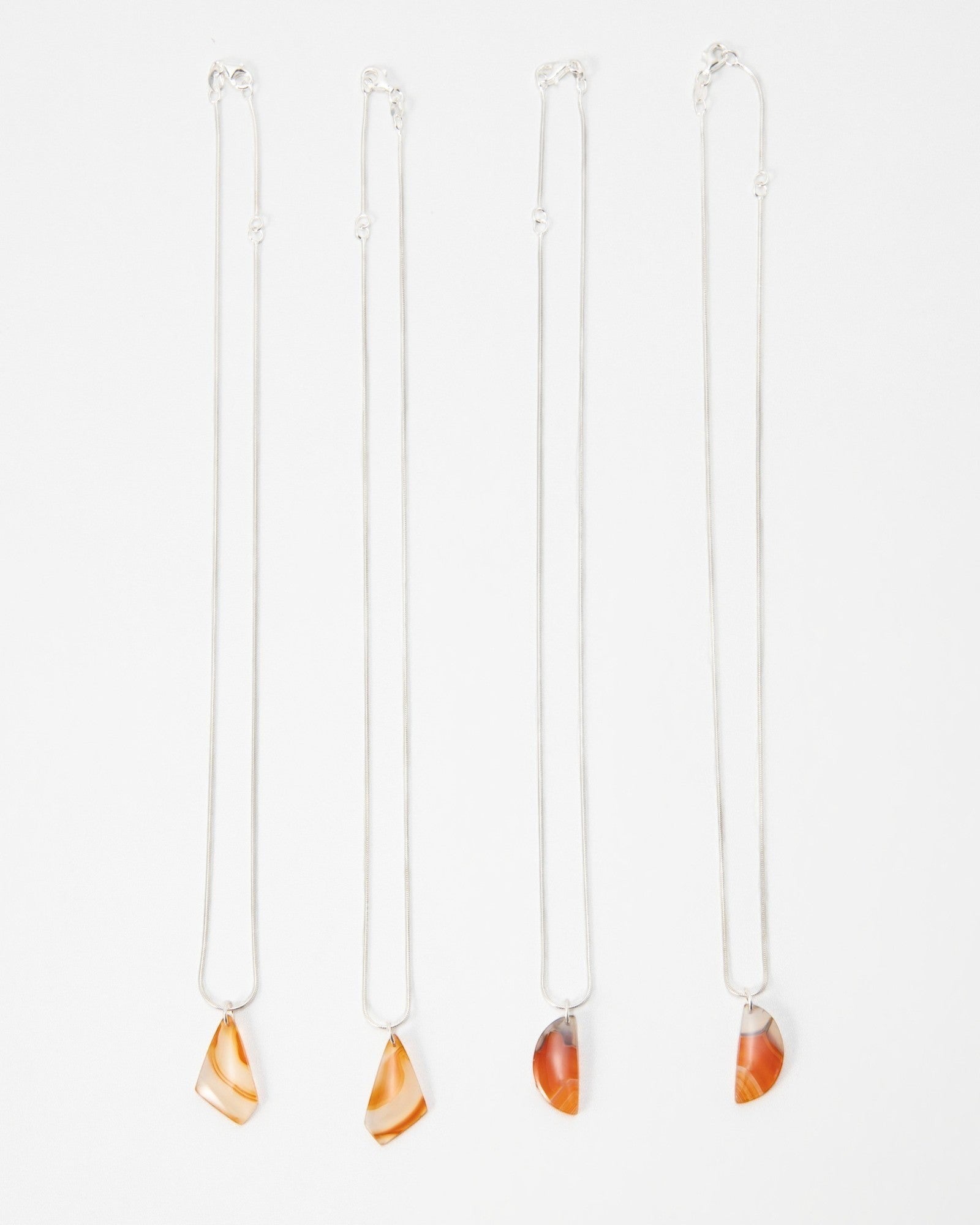 Elsita Jewelry Citrus II necklaces featuring polished orange and red agate pendants on delicate silver chains