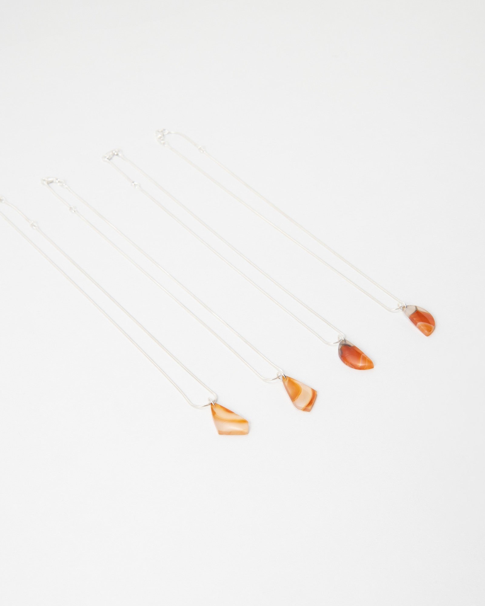 Elsita Jewelry Citrus I necklaces featuring small orange agate stone pendants on delicate silver chains