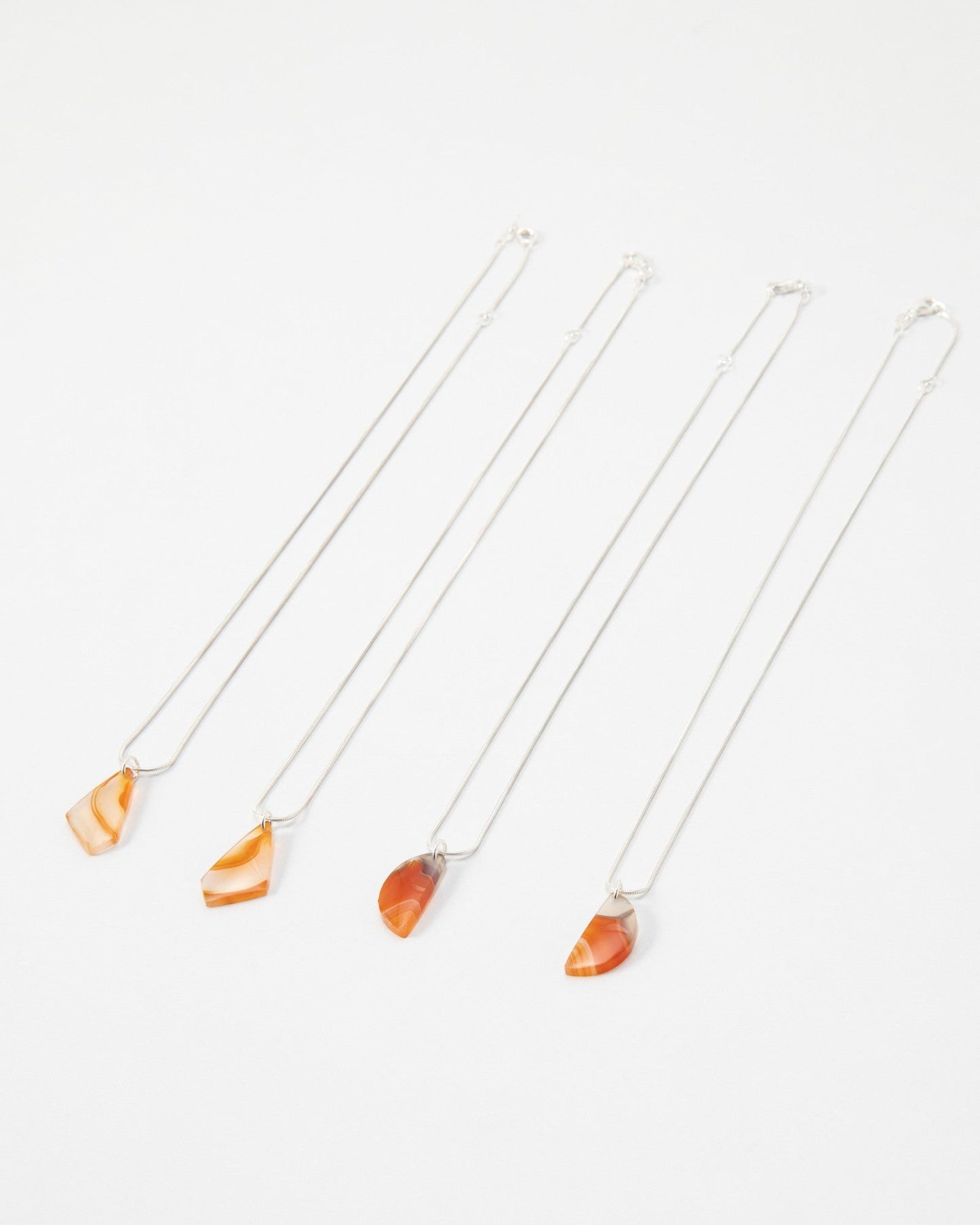 Elsita Jewelry Citrus I necklaces featuring orange and red banded agate stone pendants on delicate silver chains.