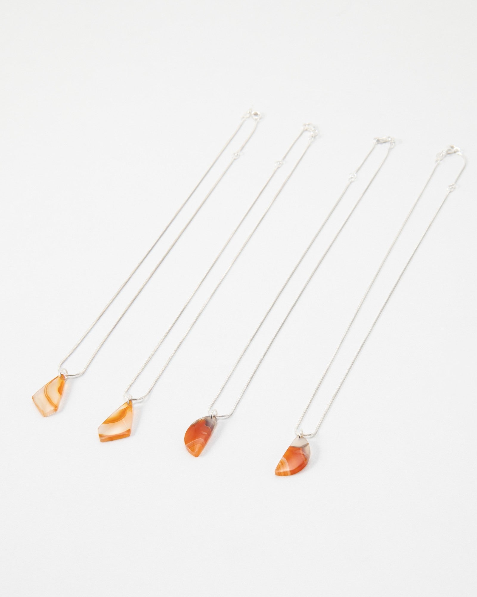 Elsita Jewelry Citrus I necklaces featuring orange and red banded agate stone pendants on delicate silver chains.