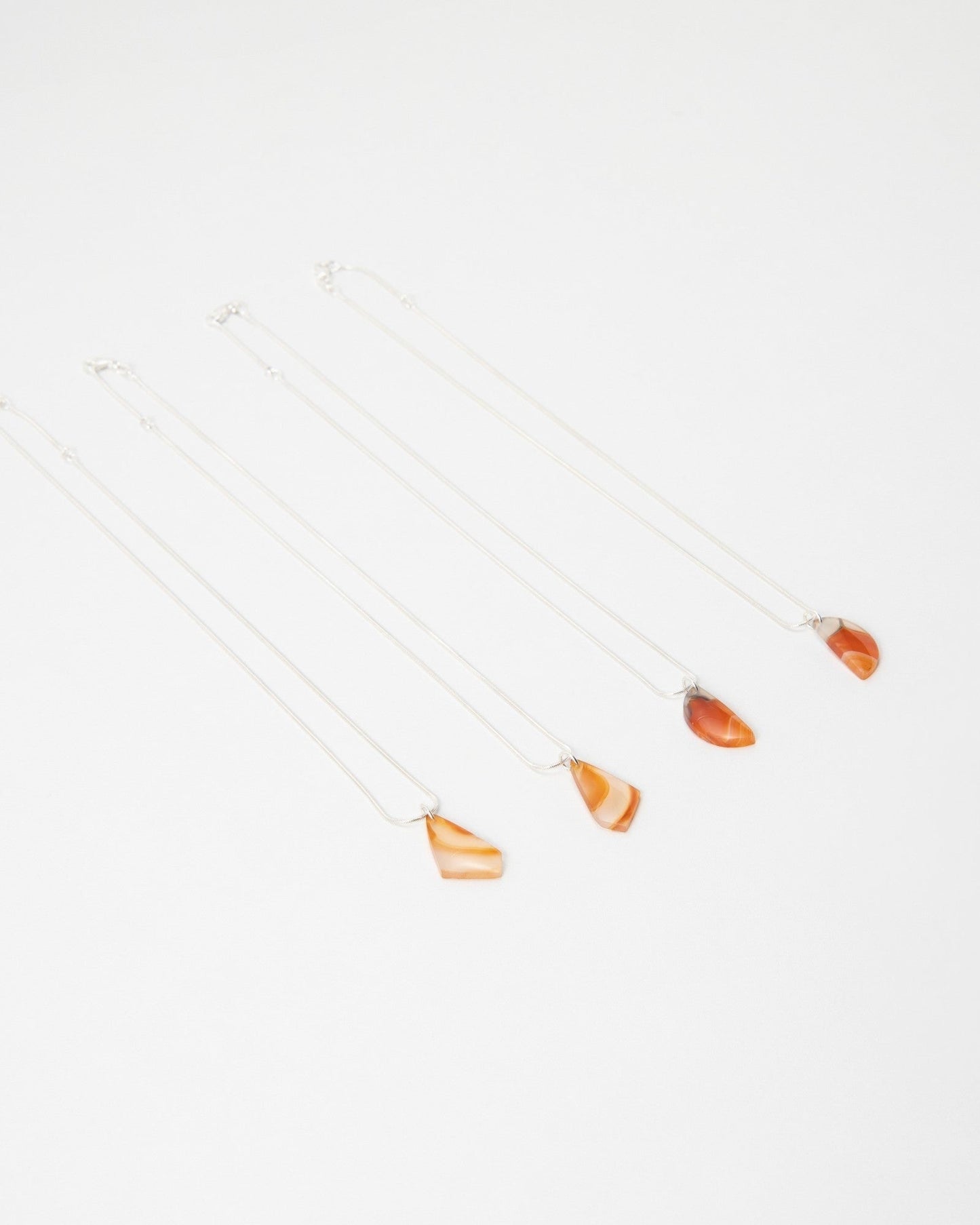 Elsita Jewelry Citrus II necklaces featuring polished orange agate stone pendants on delicate silver chains.