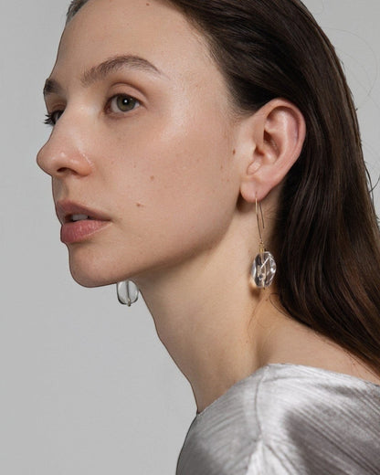 Model wearing Elsita Jewelry faceted clear quartz drop earrings with 14K gold-filled hooks and stainless-steel beads.