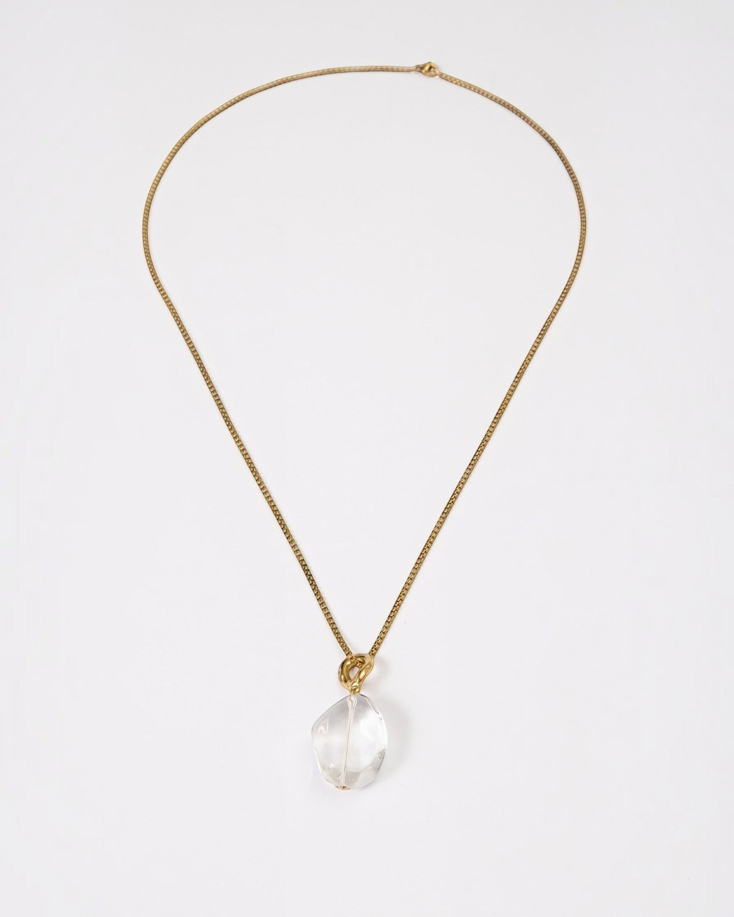 Elsita Jewelry Lustre II necklace featuring a clear quartz pendant on a delicate gold-tone stainless steel chain.