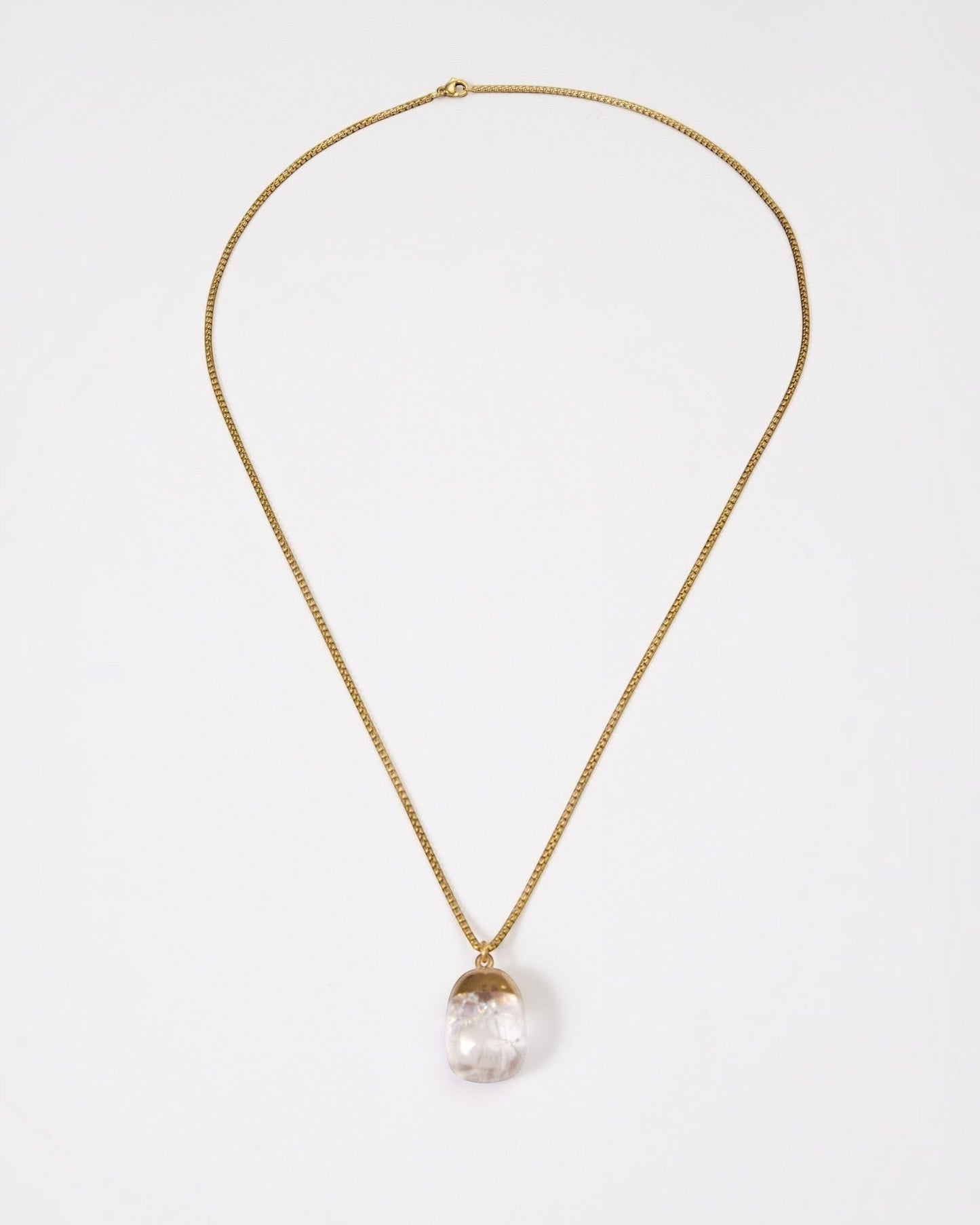 Elsita Jewelry Lustre IV necklace featuring a clear quartz pendant on a gold-toned stainless steel chain.