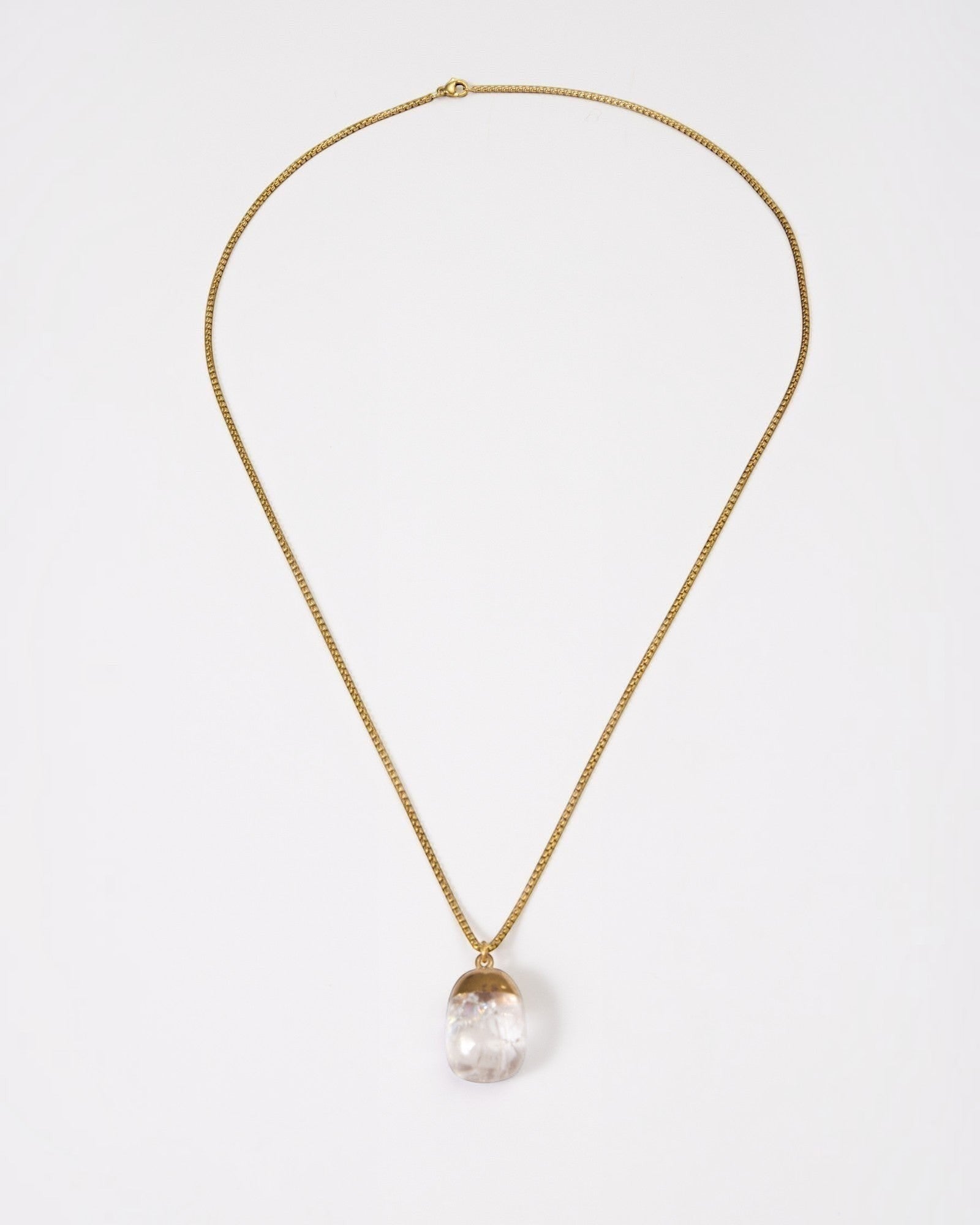 Elsita Jewelry Lustre IV necklace featuring a clear quartz pendant on a gold-toned stainless steel chain.