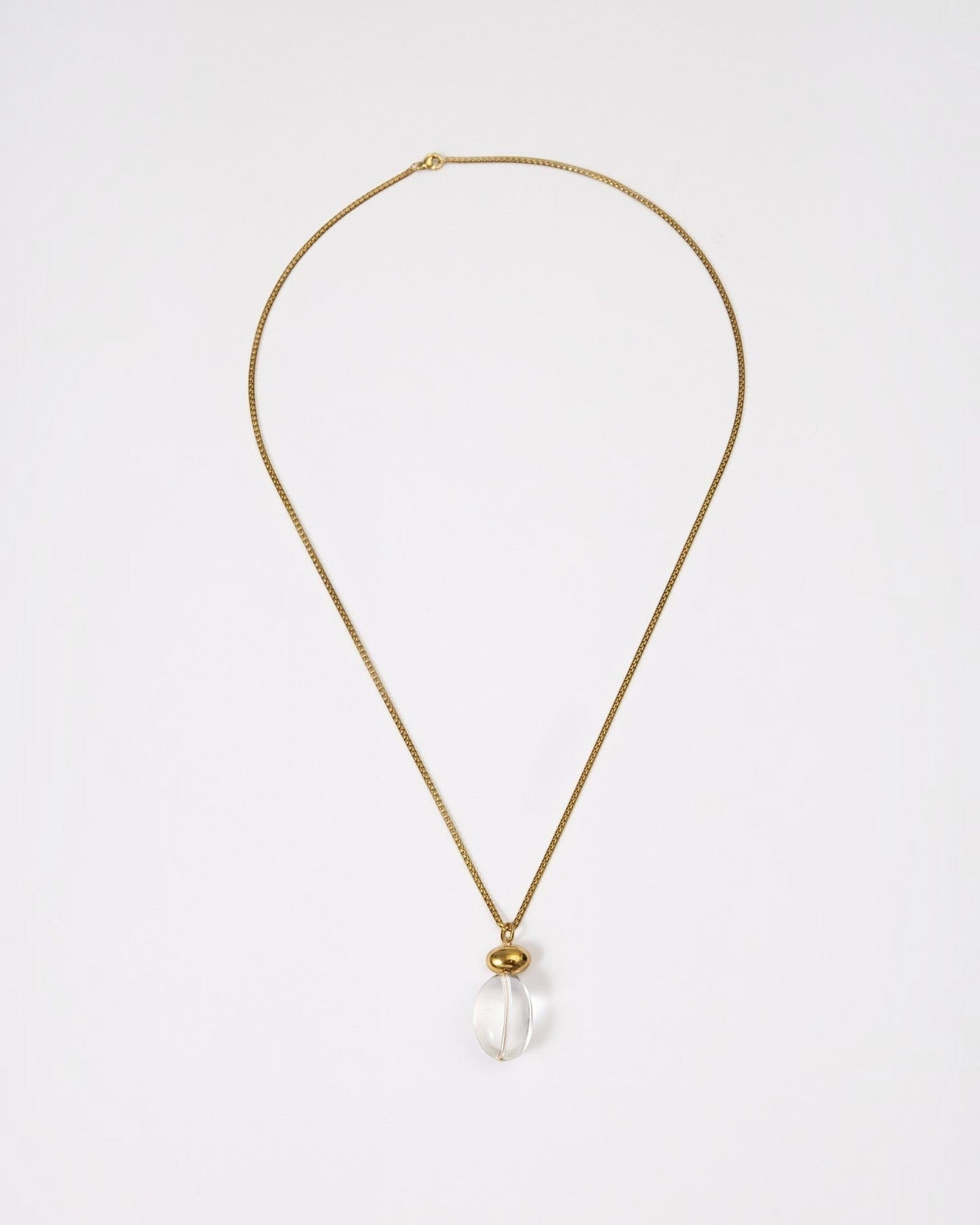 Elsita Jewelry Lustre I necklace featuring a clear quartz pendant on a gold-tone stainless steel chain