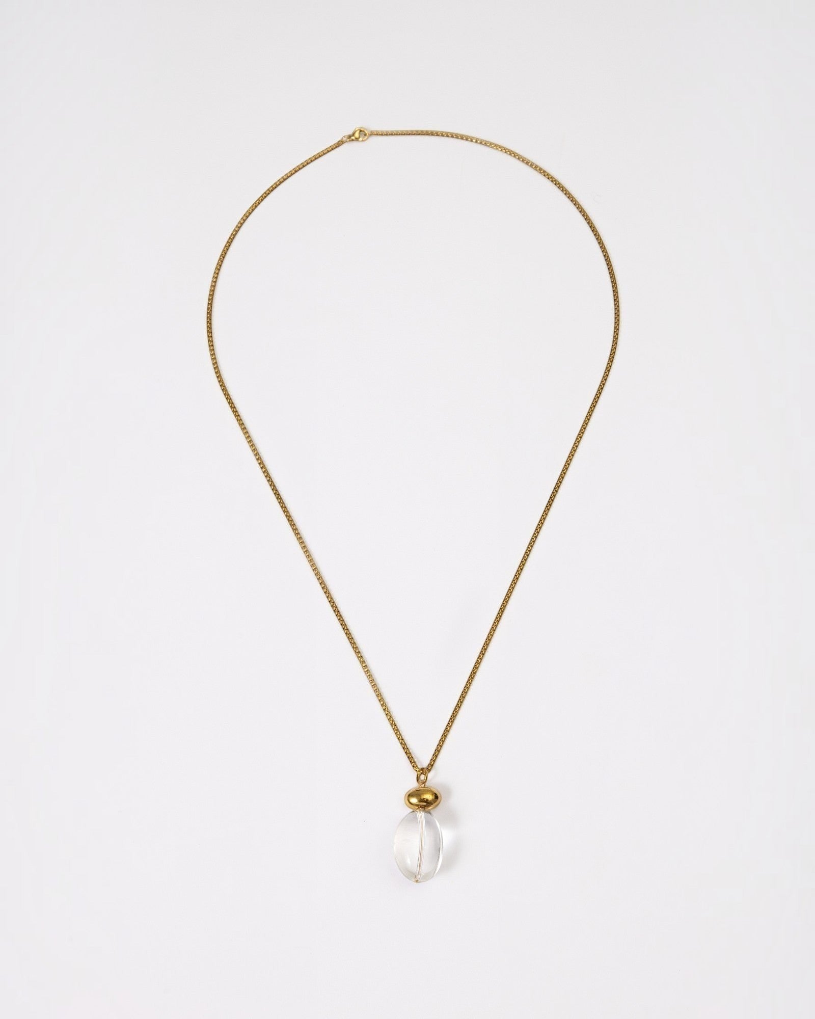 Elsita Jewelry Lustre I necklace featuring a clear quartz pendant on a gold-tone stainless steel chain