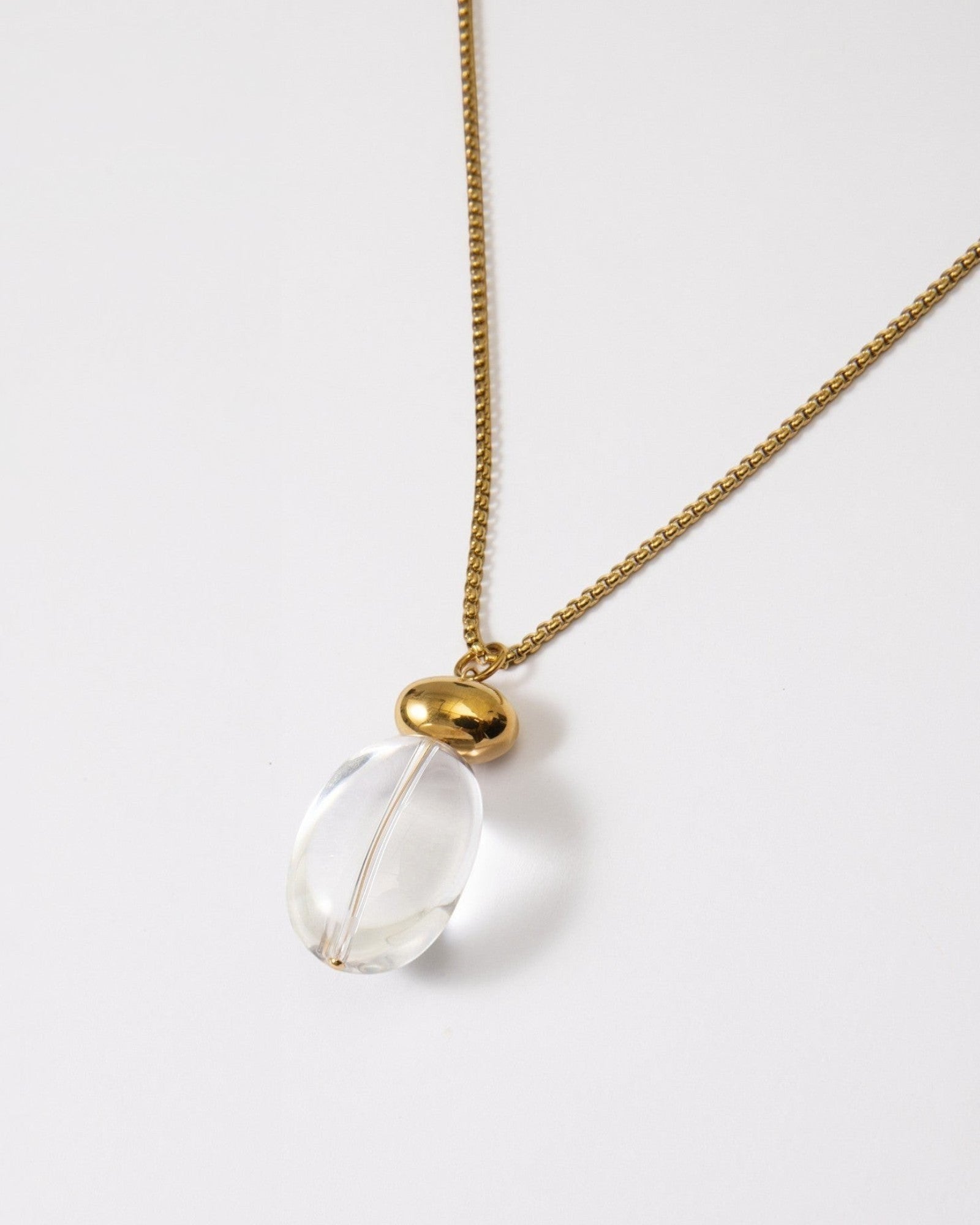 Elsita Jewelry Lustre I necklace featuring a clear quartz pendant on a polished gold-tone stainless steel chain.