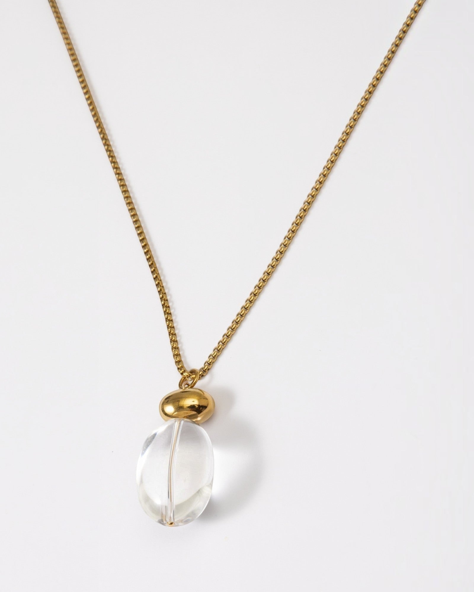 Elsita Jewelry Lustre I necklace featuring a clear quartz pendant on a polished gold-tone stainless steel chain.