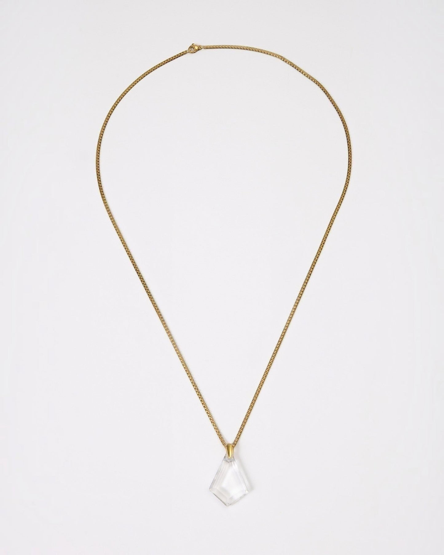 Elsita Jewelry Lustre III necklace featuring a clear quartz pendant on a gold-toned stainless steel chain.