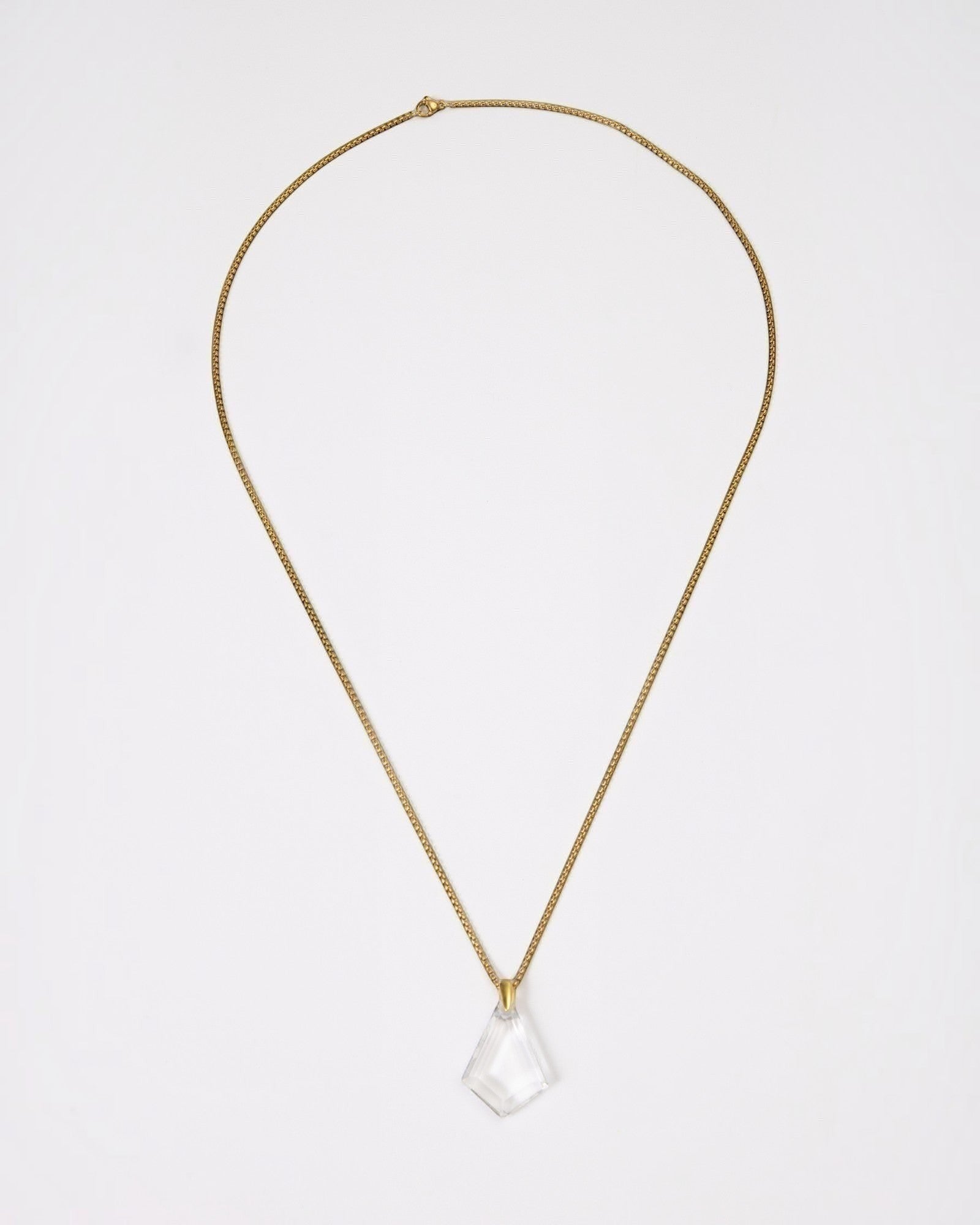 Elsita Jewelry Lustre III necklace featuring a clear quartz pendant on a gold-toned stainless steel chain.