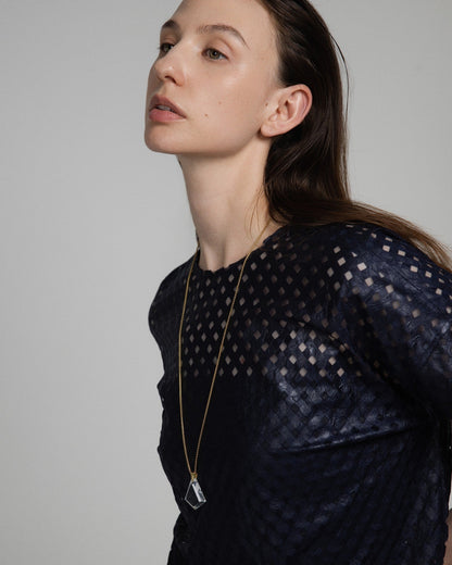 Model wearing an Elsita Jewelry Lustre III clear quartz pendant necklace on a gold-tone stainless steel chain.