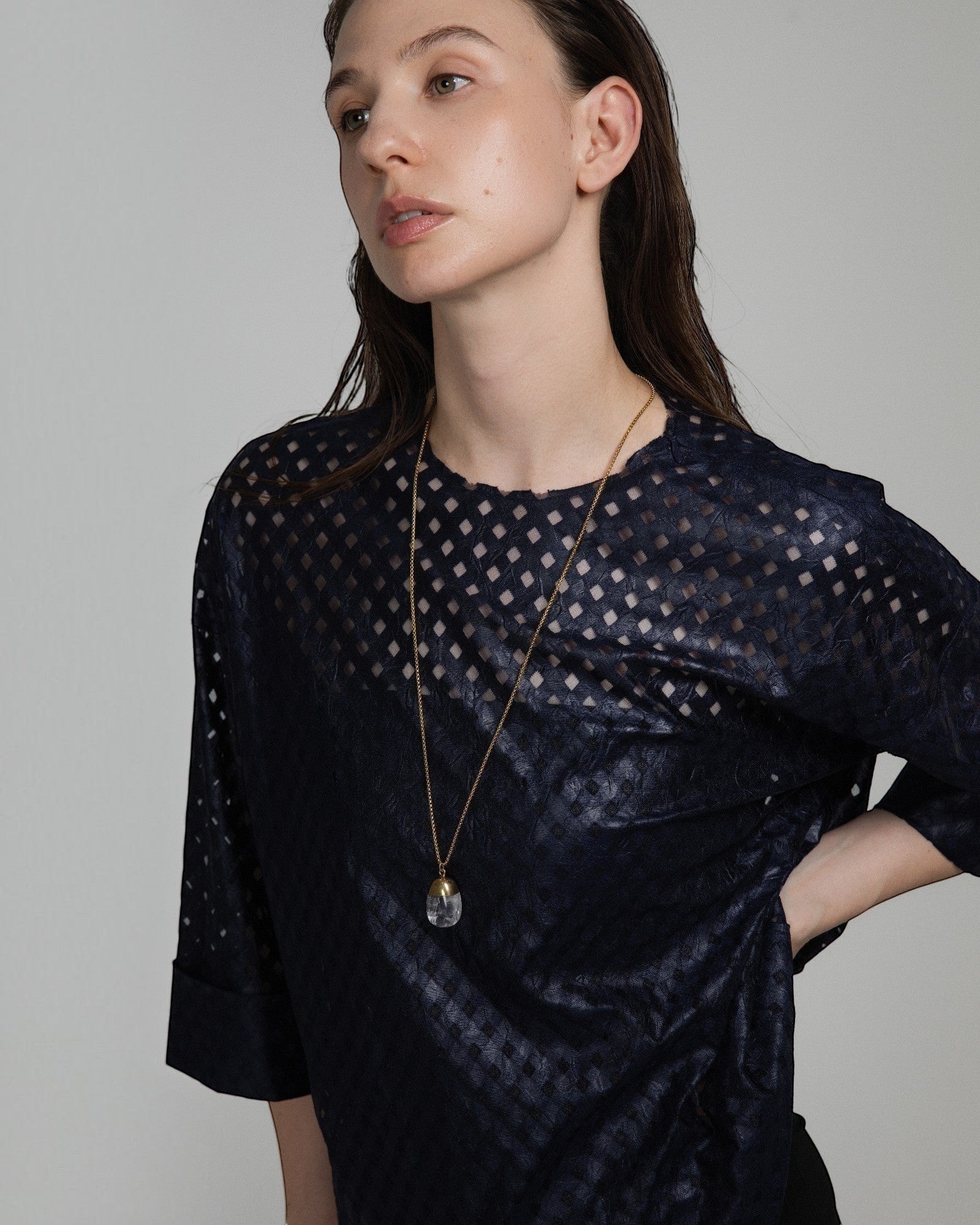 Elsita Jewelry Lustre IV necklace featuring a clear quartz pendant with gold-toned stainless steel on a long chain.
