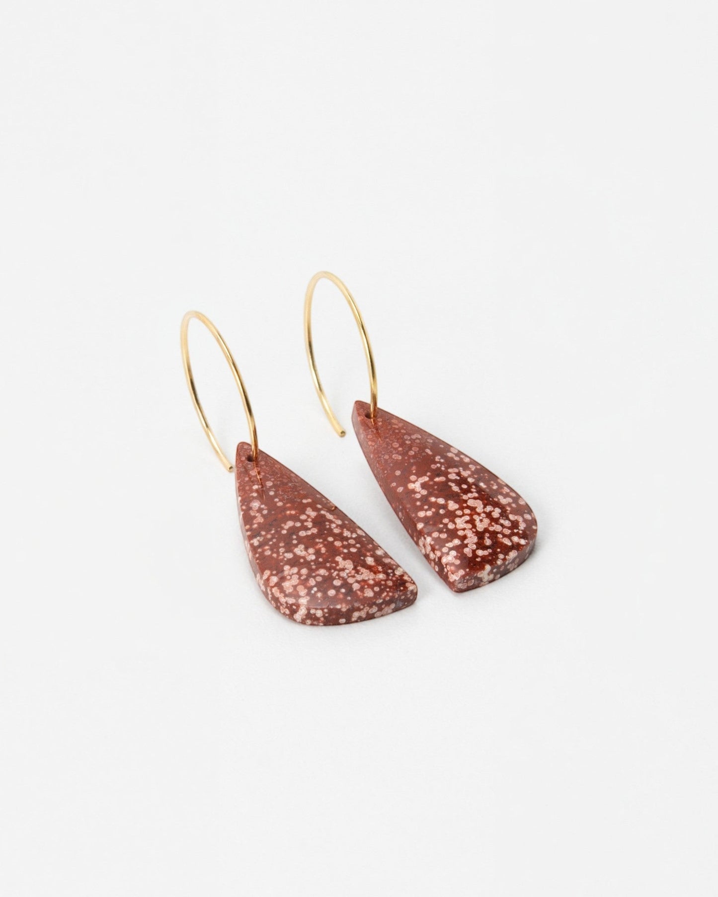 Elsita Jewelry Coral earrings featuring speckled terracotta-colored teardrop pendants on delicate gold hoops.