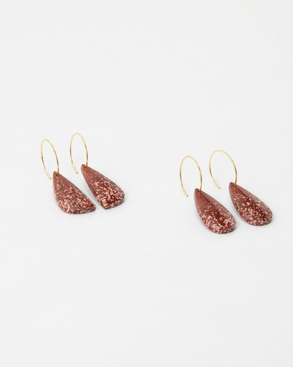 Elsita Jewelry Coral earrings featuring teardrop-shaped speckled terracotta clay charms on thin gold hoop wires.