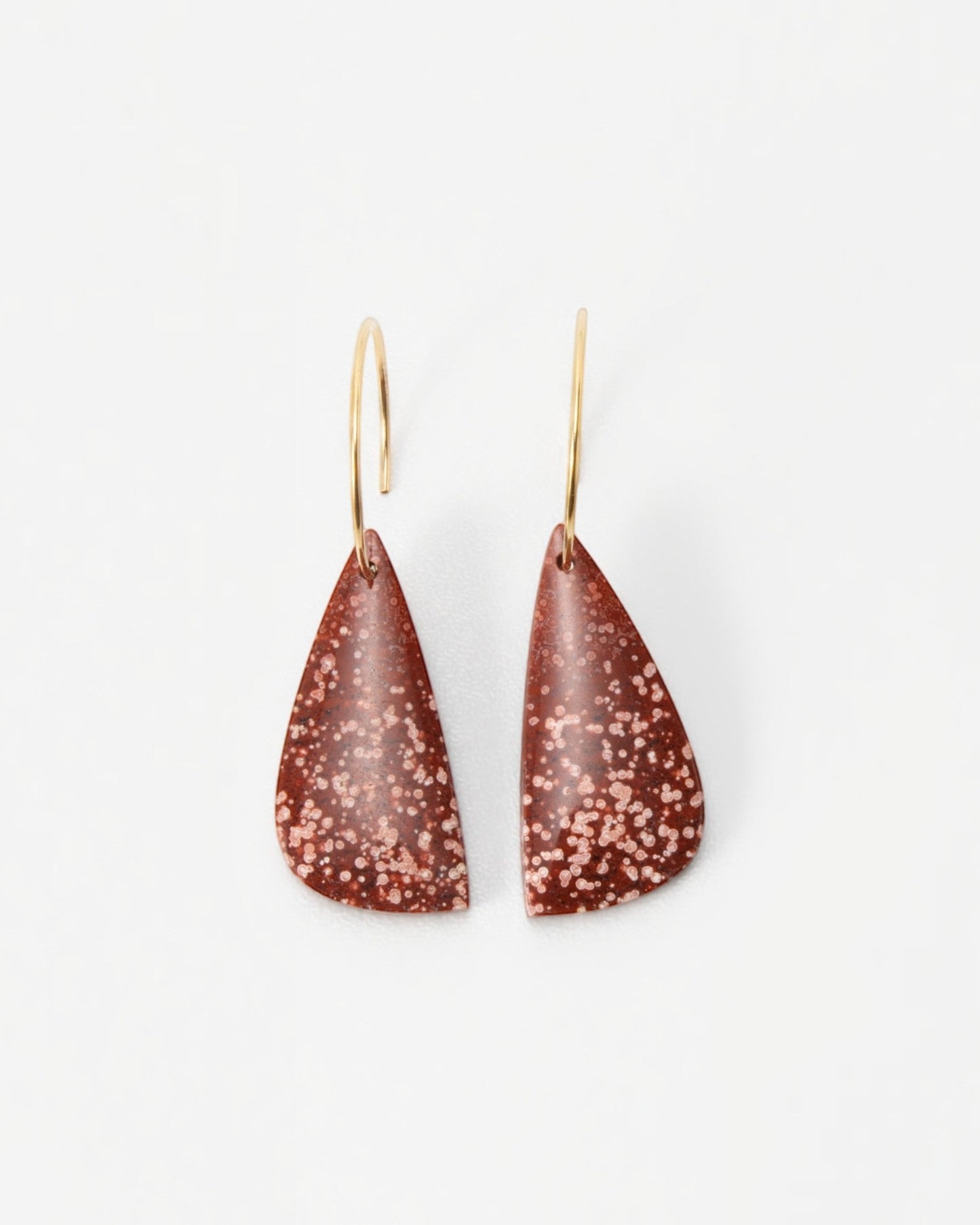 Elsita Jewelry Coral earrings featuring teardrop-shaped terracotta clay pendants with white speckles on gold hoops.