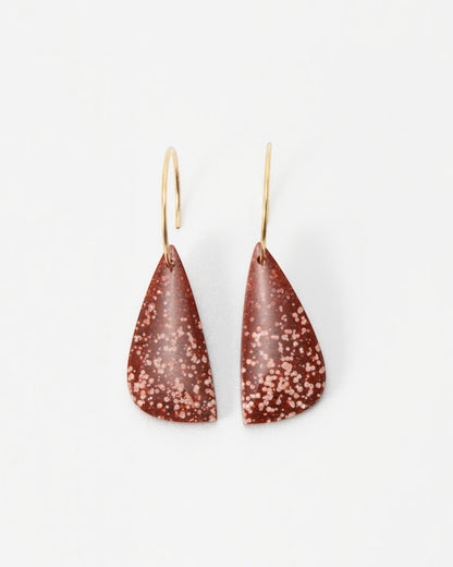 Elsita Jewelry Coral earrings featuring teardrop-shaped terracotta clay pendants with white speckles on gold hoops.