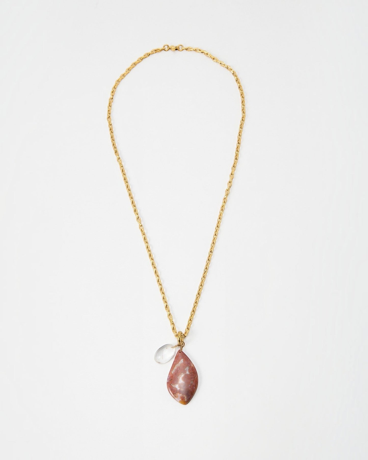 Elsita Jewelry Drift necklace featuring a gold chain with a teardrop-shaped pink stone and a small clear crystal charm.