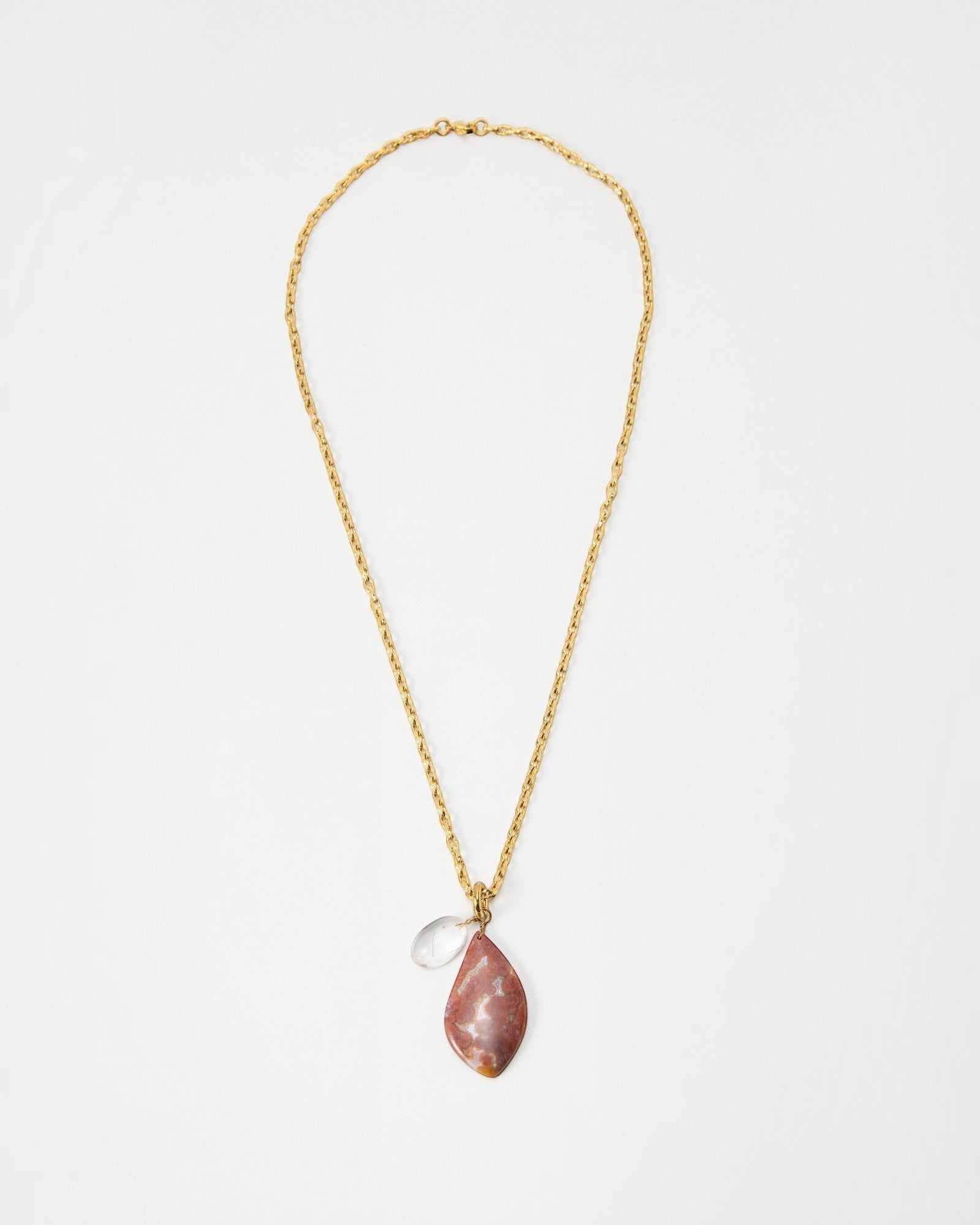 Elsita Jewelry Drift necklace featuring a gold chain with a teardrop-shaped pink stone and a small clear crystal charm.