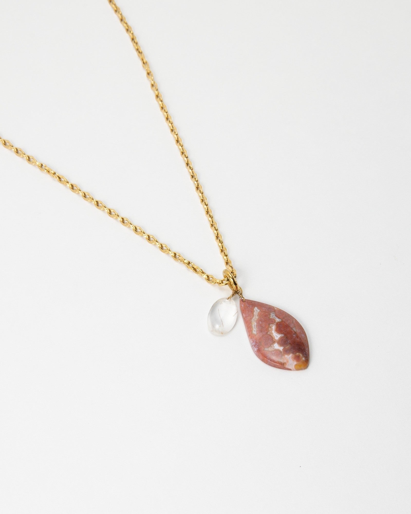 Elsita Jewelry Drift necklace featuring a teardrop-shaped pink stone and clear crystal charm on a gold rope chain.