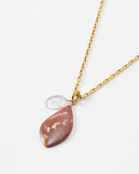 Elsita Jewelry Drift necklace featuring a teardrop-shaped red jasper stone and a small clear crystal on a gold chain.