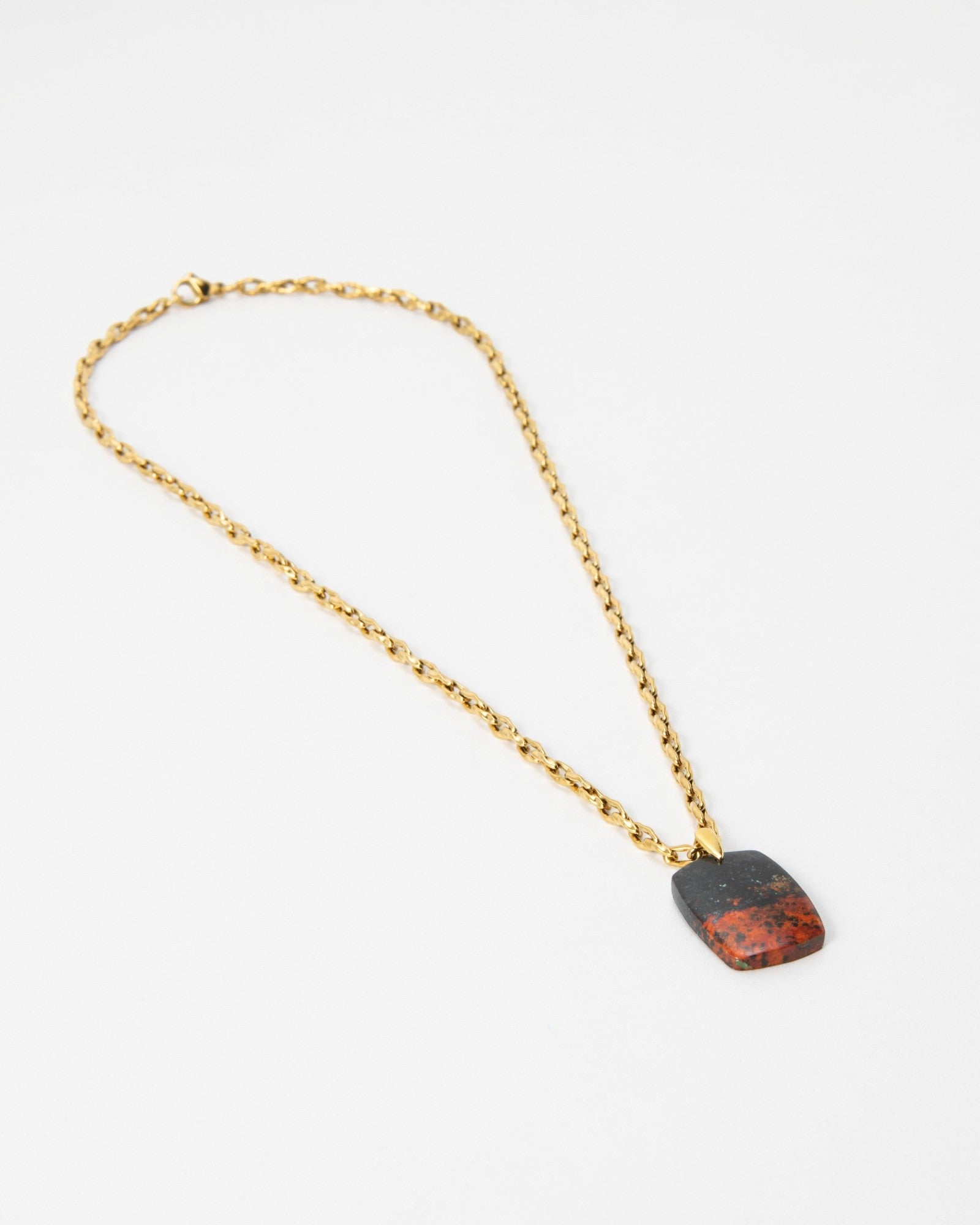 Elsita Jewelry Dune Day necklace featuring a rectangular red and black stone pendant on a gold chain.