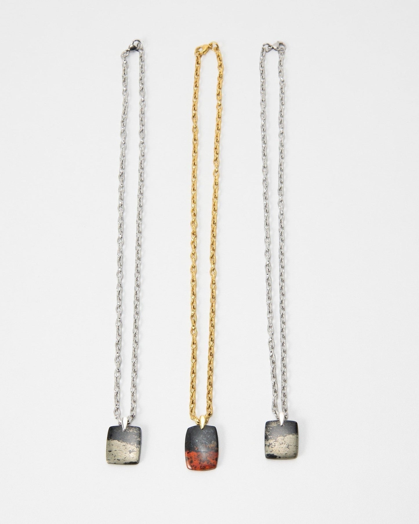 Elsita Jewelry Dune Day necklaces featuring square stone pendants on silver and gold chains against a white background