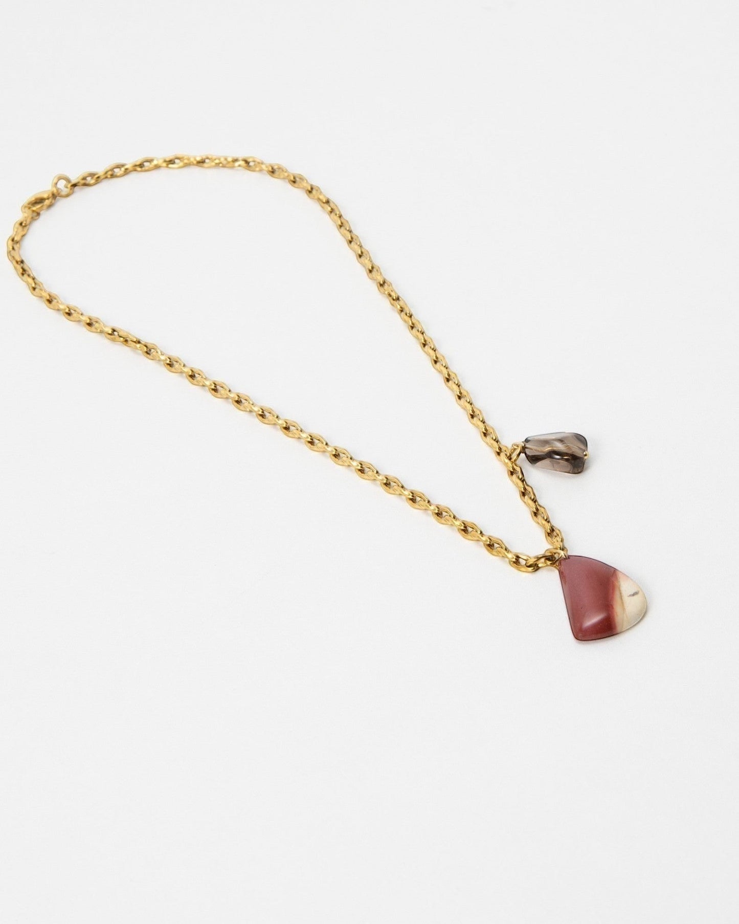Elsita Jewelry Ember necklace featuring a gold chain with a polished red and cream stone pendant and small charm